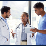 Three clinicians standing together talking.