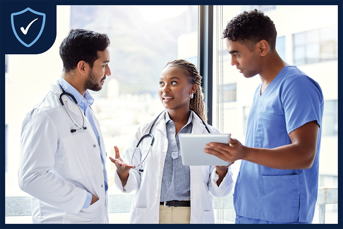 Three clinicians standing together talking.