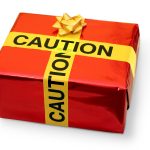 A holiday gift is wrapped with paper and caution tape.