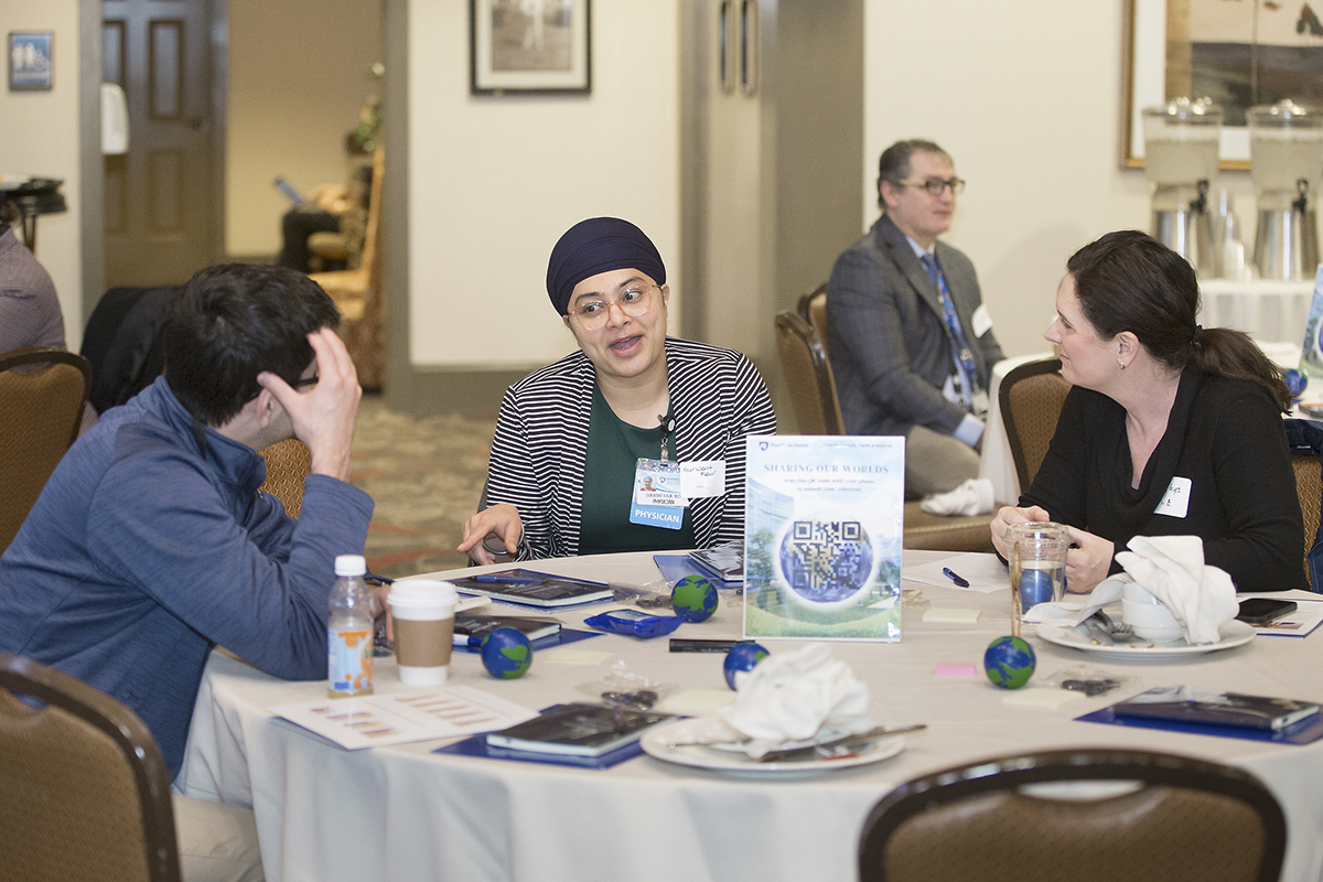 Individuals sitting at a round table talking