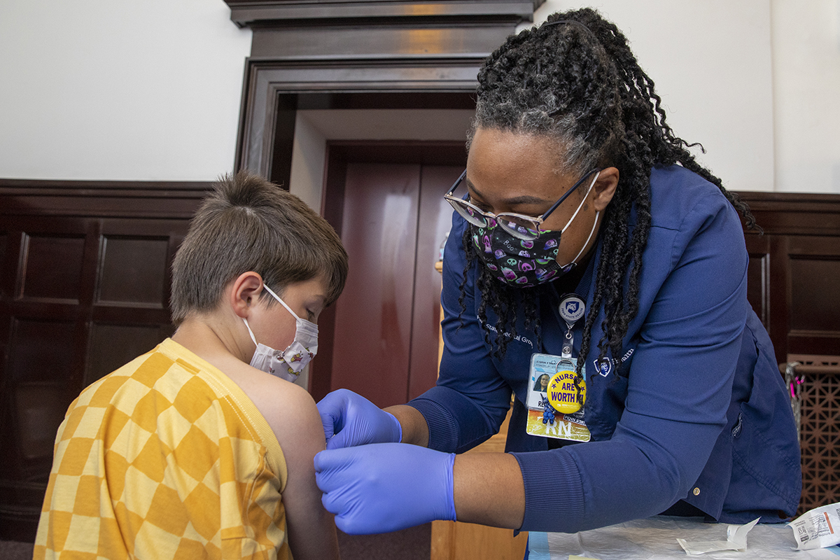 A nurse administering a shot to a male child