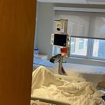 An image of a hospital room with a flat screen monitor suspended above it.