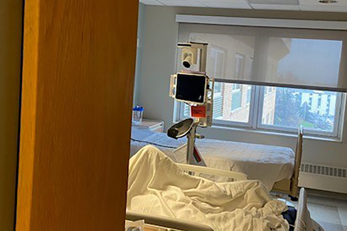 An image of a hospital room with a flat screen monitor suspended above it.