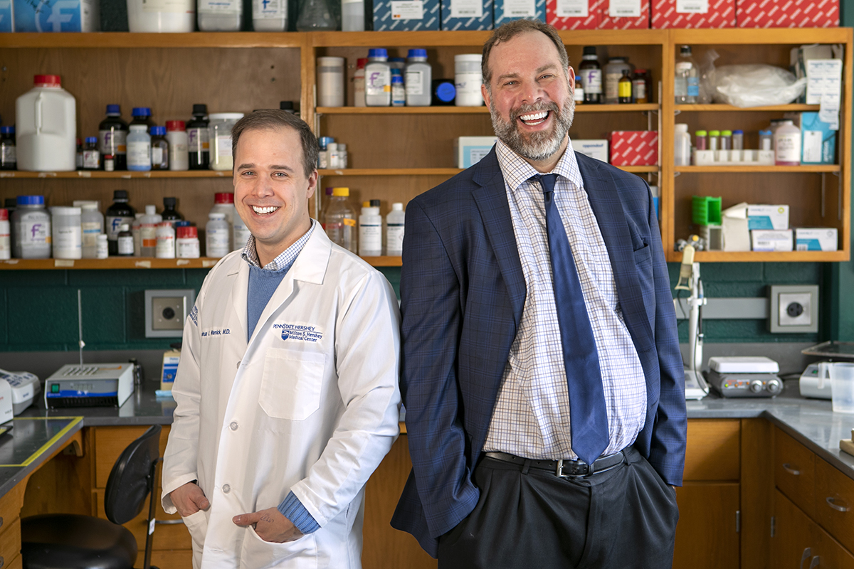 Joshua Warrick and David DeGraff pose for a photo in a laboratory.