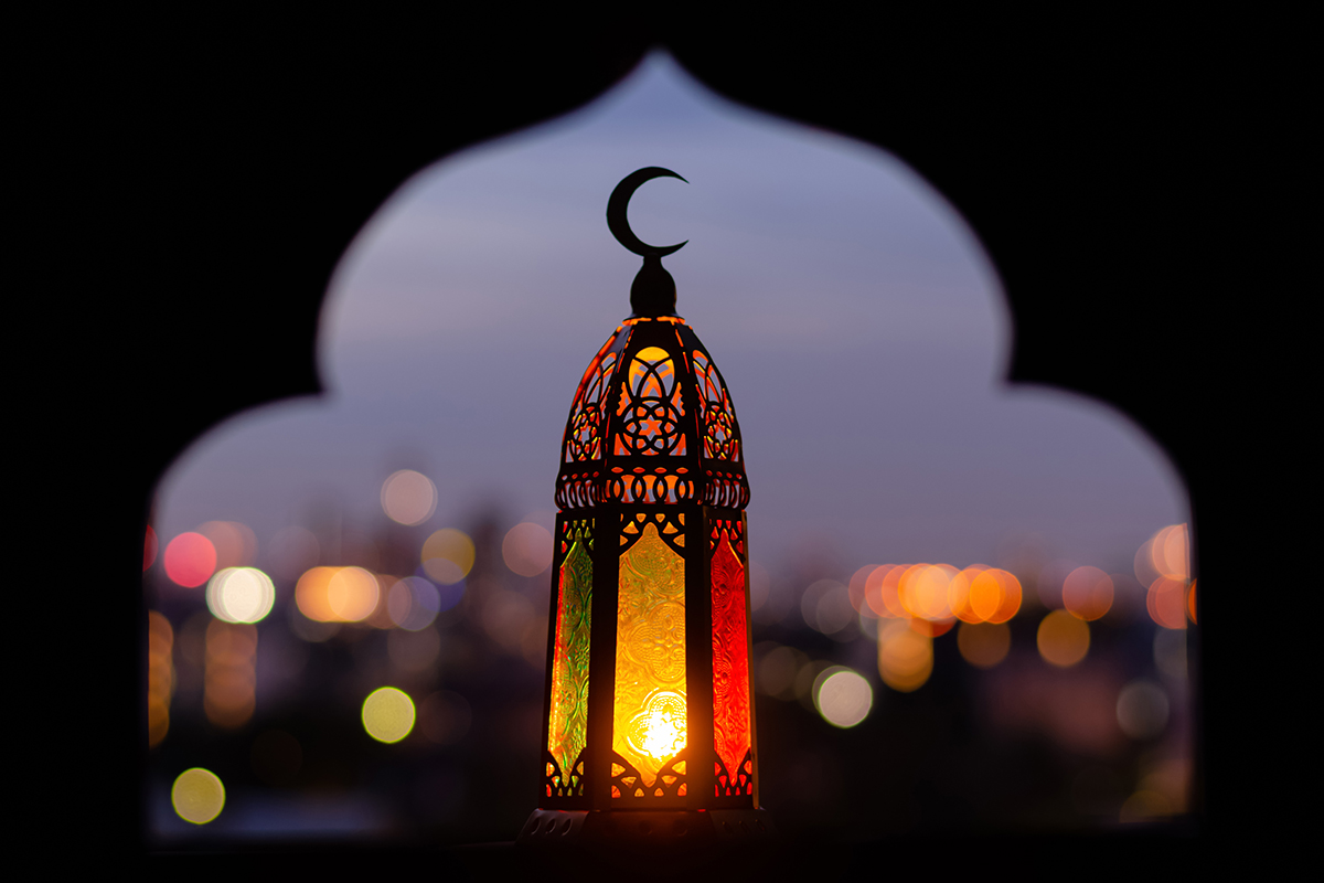 Lantern with moon finial, silhouetted again a blurred city scape.