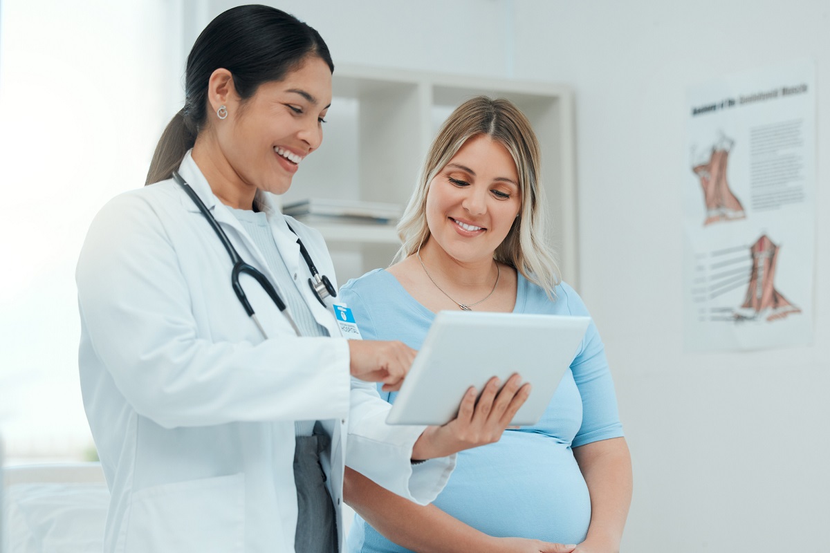 A doctor consults with a pregnant patient in a clinic.