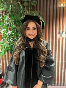 Noor Kawmi poses for a photo wearing her commencement regalia.