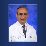 Portrait of Dr. Nasrollah Ghahramani in doctor's coat, on a gradient background