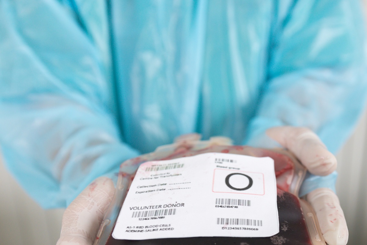 A health care worker holds a bag of donated blood.