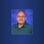 A portrait of Dwayne Ramsey wearing a button up shirt.