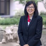 Karen Kim, MD, poses in front of the nittany lion statue in the courtyard outside Penn State College of Medicine.