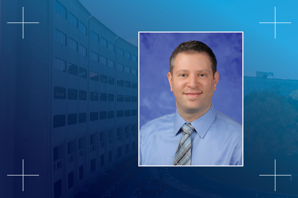 A head and shoulders professional portrait of Yuval Silberman, PhD, against a faded background image of Penn State College of Medicine.