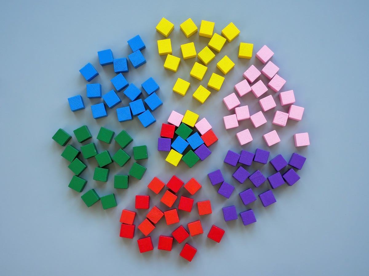 6 groups of cubes, each a pile of a single, distinct color, surround a multicolored pile that is made of up of cubes from each individual pile surrounding them.