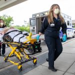 Emma Anselmo, foreground, and Caira Whitney, emergency medical technicians with Penn State Health Life Lion, LLC transport Donald Gray from the ambulance to his rehabilitation on Friday, July 8, 2022.