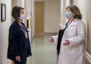 Penn State Health Milton S. Hershey Medical Center RN, Aileen McCormick and a fellow RN talk in a hallway