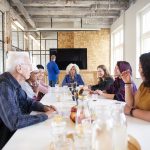 Mixed team talking and waiting for the monitor to be set up at a hand lettering workshop