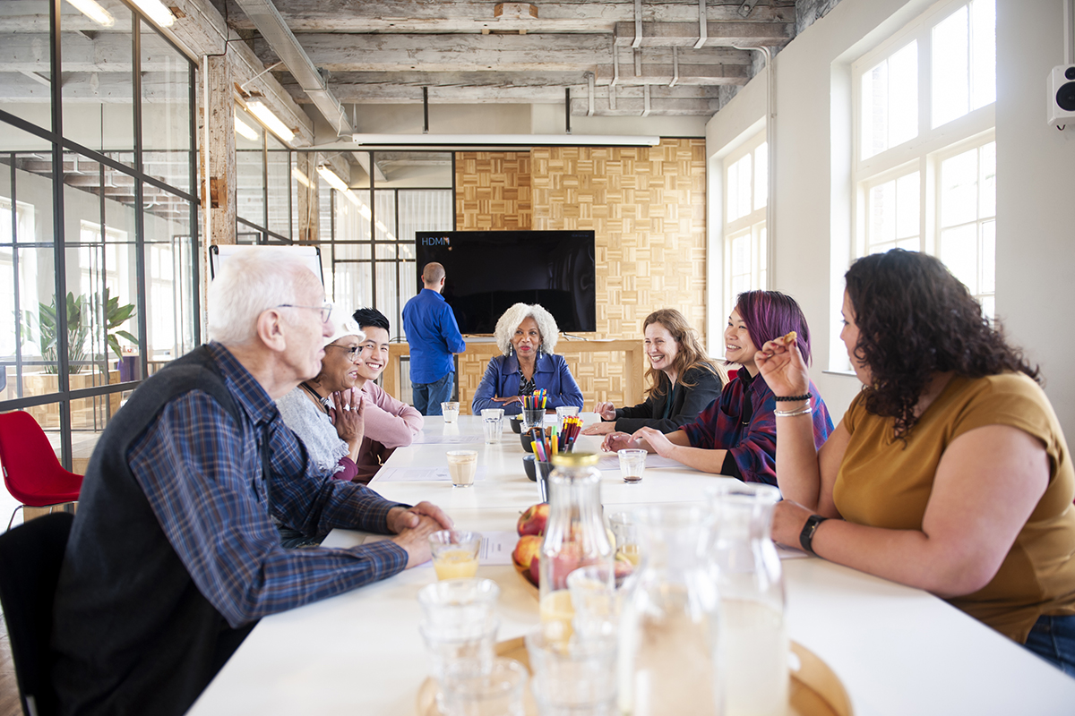 Mixed team talking and waiting for the monitor to be set up at a hand lettering workshop