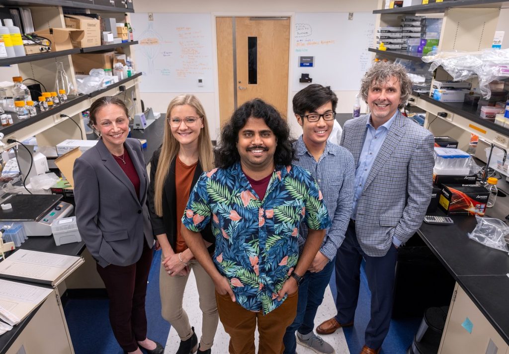 5 people stand for a photo together inside a Penn State College of Medicine laboratory.