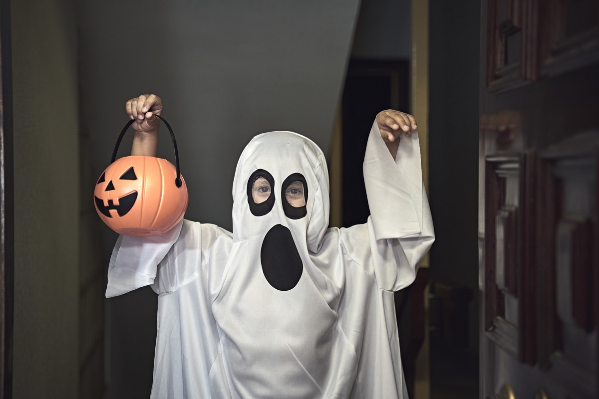 A little boy dressed as a ghost.