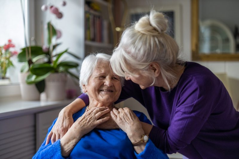 A woman comforts her elderly mother.