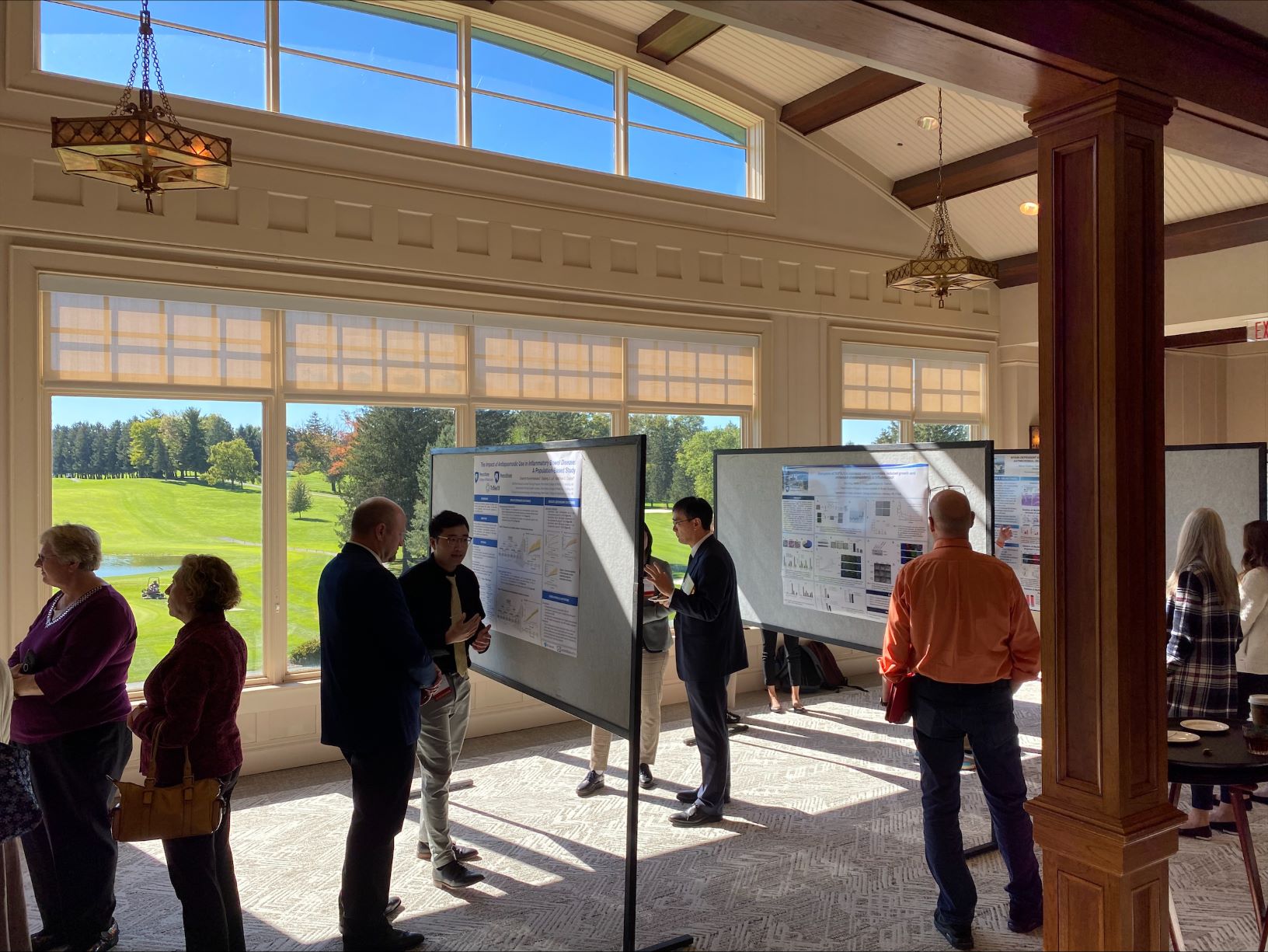 Individuals gather around research posters during the Inflammatory Bowel Disease Research Symposium on Friday, Oct. 13 at Hershey Country Club.