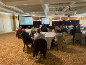 Several rows of people are seated in a conference room, listening to a speaker, at the Inflammatory Bowel Disease Research Symposium on Friday, Oct. 13 at the Hershey Country Club.