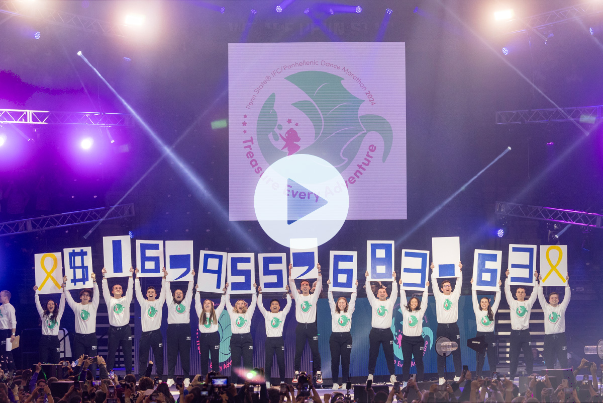 People on stage at THON hold up numbers to show how much was raised in 2024: $16,955,683.63.