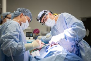 Two doctors perform surgery on a patient in an operating room.