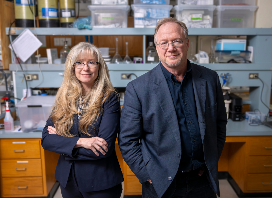 Two people pose for a portrait in a research lab.
