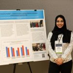 Asma Khursheed stands next to her poster she presented