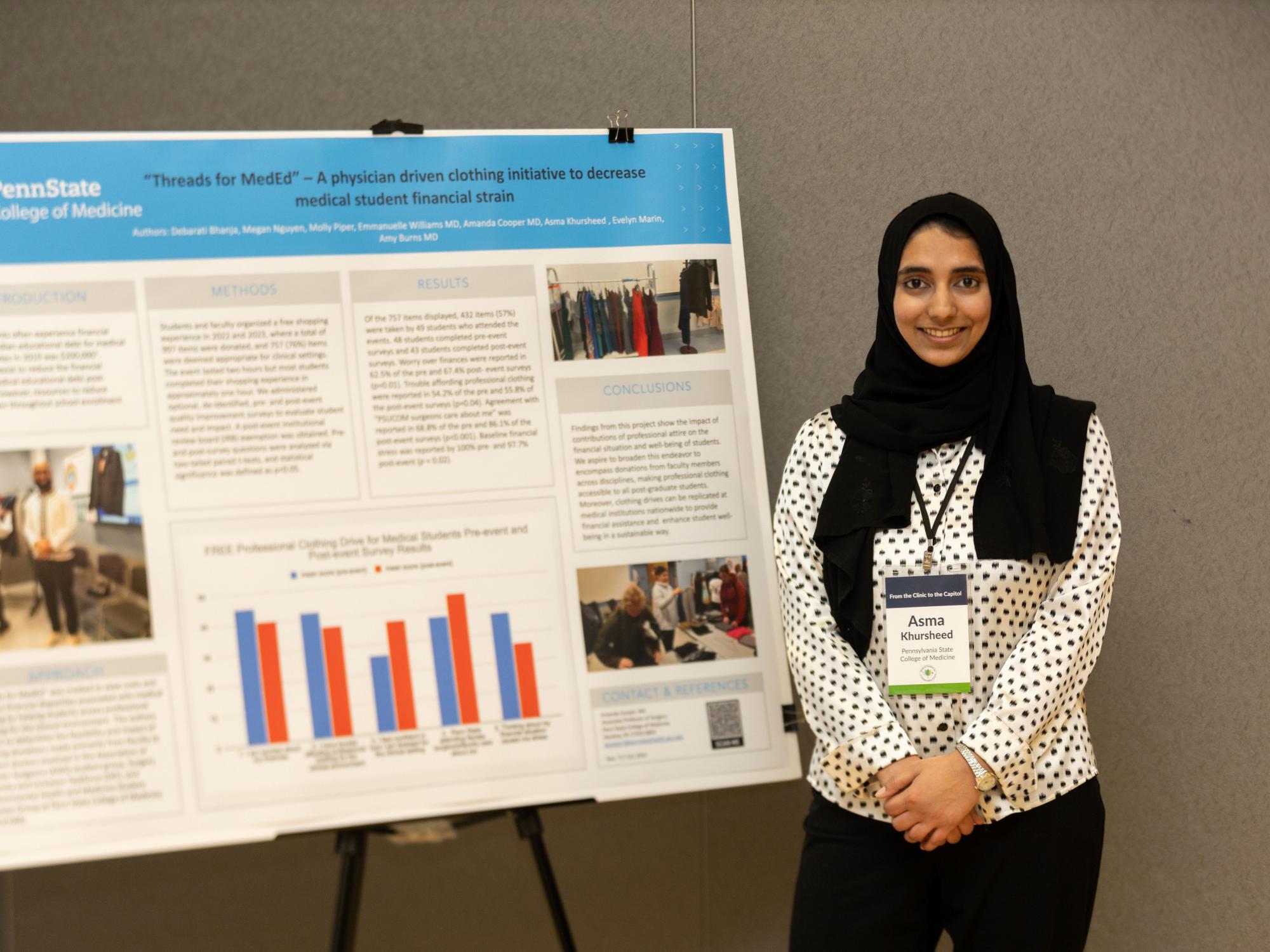 Asma Khursheed stands next to her poster she presented