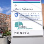 Photo of brick building in background with a sign that reads Pennsylvania Psychiatric Institute.