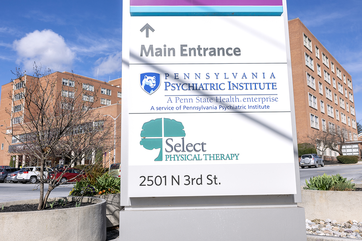 Photo of brick building in background with a sign that reads Pennsylvania Psychiatric Institute.