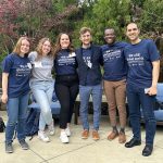 Six people, all College of Medicine Global Health Scholar competition participants, stand in a line; five are wearing We Are Global Health shirts.