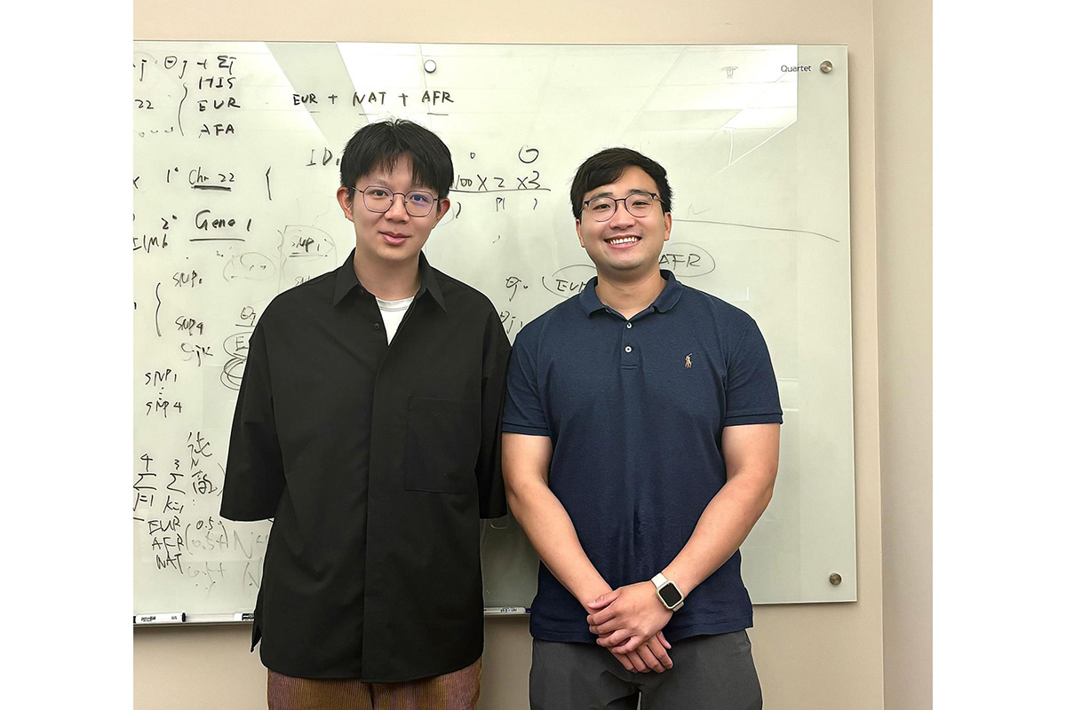 Lida Wang and Chachrit Khunsriraksakul stand in front of a white board with equations on it