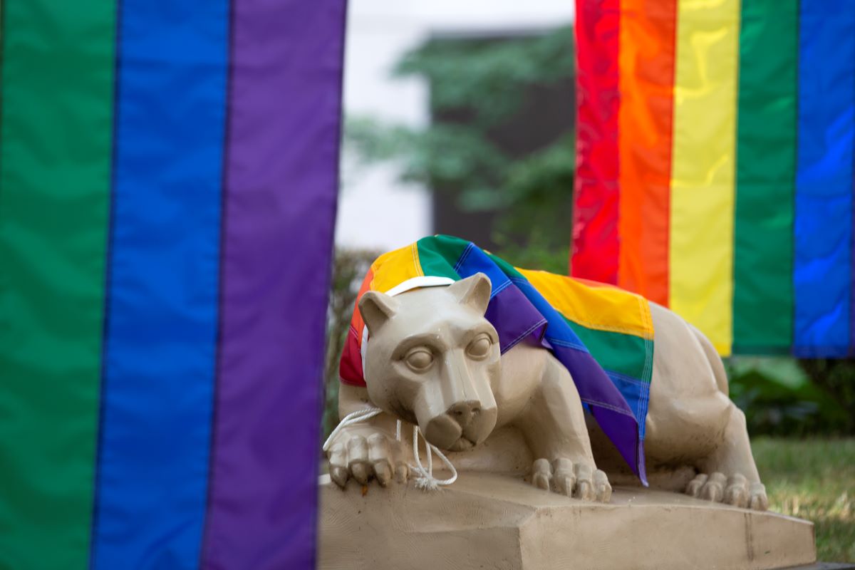 Rainbow pride flags surround the Nittany Lion.