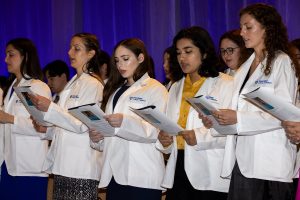 A group of medical students wearing their new white coats recite the Hippocratic Oath at their White Coat Ceremony