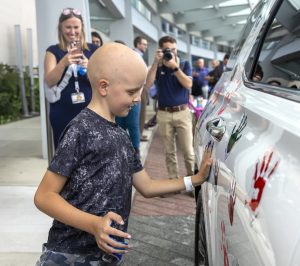 A young child adds his handprint to a Hyundai SUV