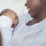 A baby lays on a mother's chest