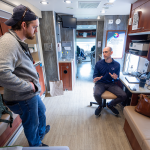 Two men talk inside a mobile medical clinic