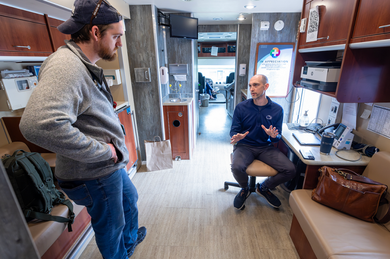 Two men talk inside a mobile medical clinic