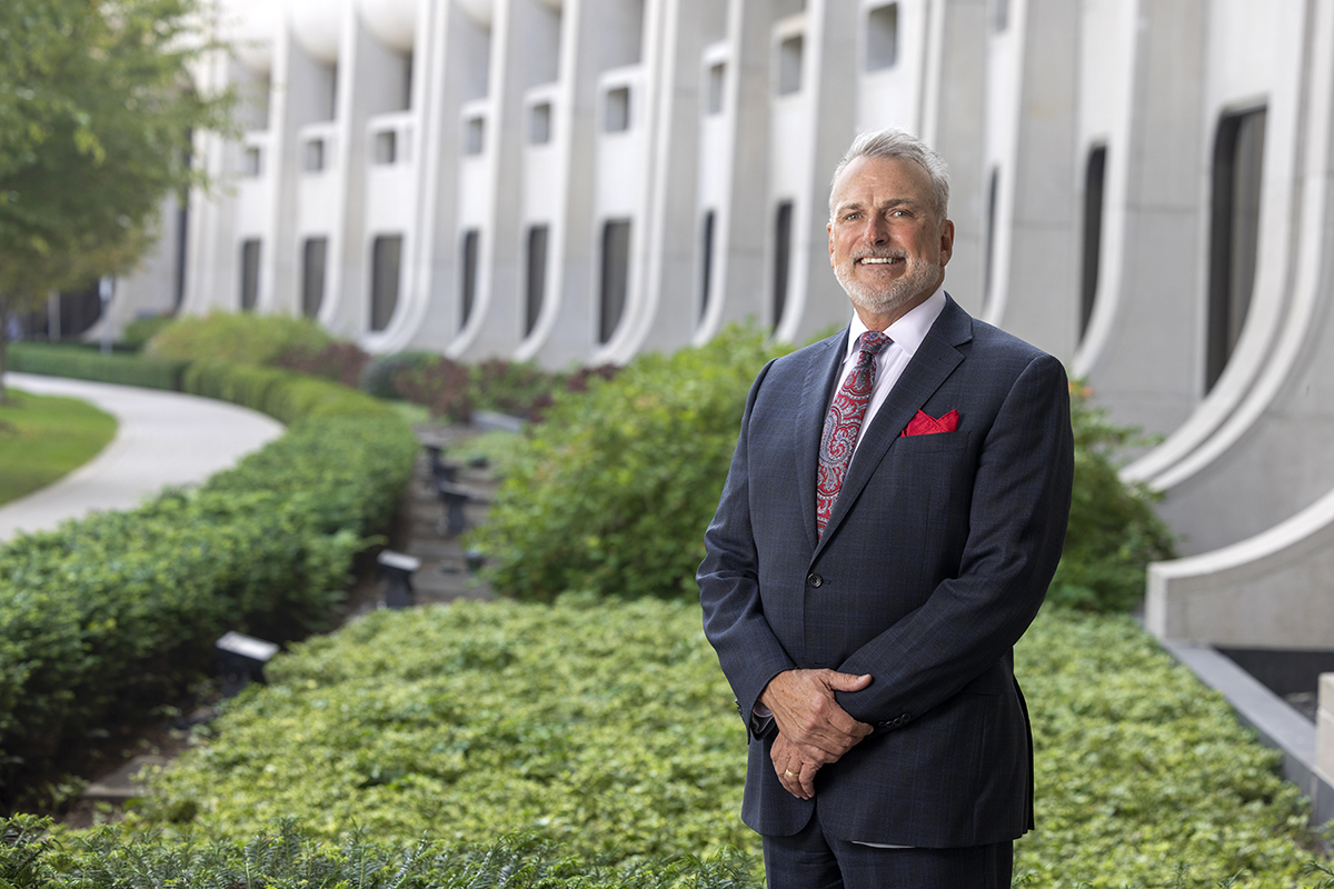 Kent Vrana, PhD, stands outside the Penn State College of Medicine crescent building with his arms folded for a professional portrait.