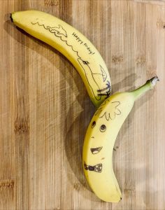 A picture of a banana with drawings on the skin.