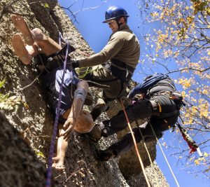 Medical student rappel down the side of climbing rocks during a training exercise