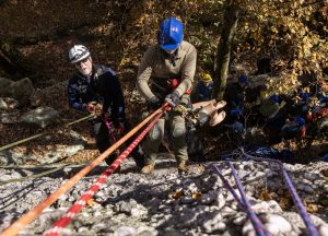 Students and trainers reppel down the side of climbing rocks during a training exercise