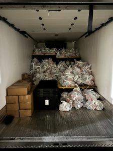 The interior of a vehicle filled with bagged food parcels.