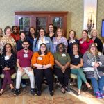 A group of people who participated in the inaugural Geriatric Scholars Program stand and sit for a photo at the Hershey Country Club in September 2024