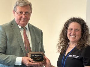 Two people holding an award between them; winner Rollin Wright is on the right.