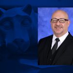 A headshot of a man smiling is overlaid on a blue background that has a statue of a lion mascot