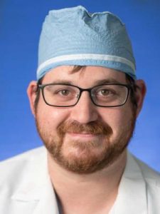 Dr. Werter in a professional head and shoulders photograph. He is wearing a surgical cap and a white medical jacket.